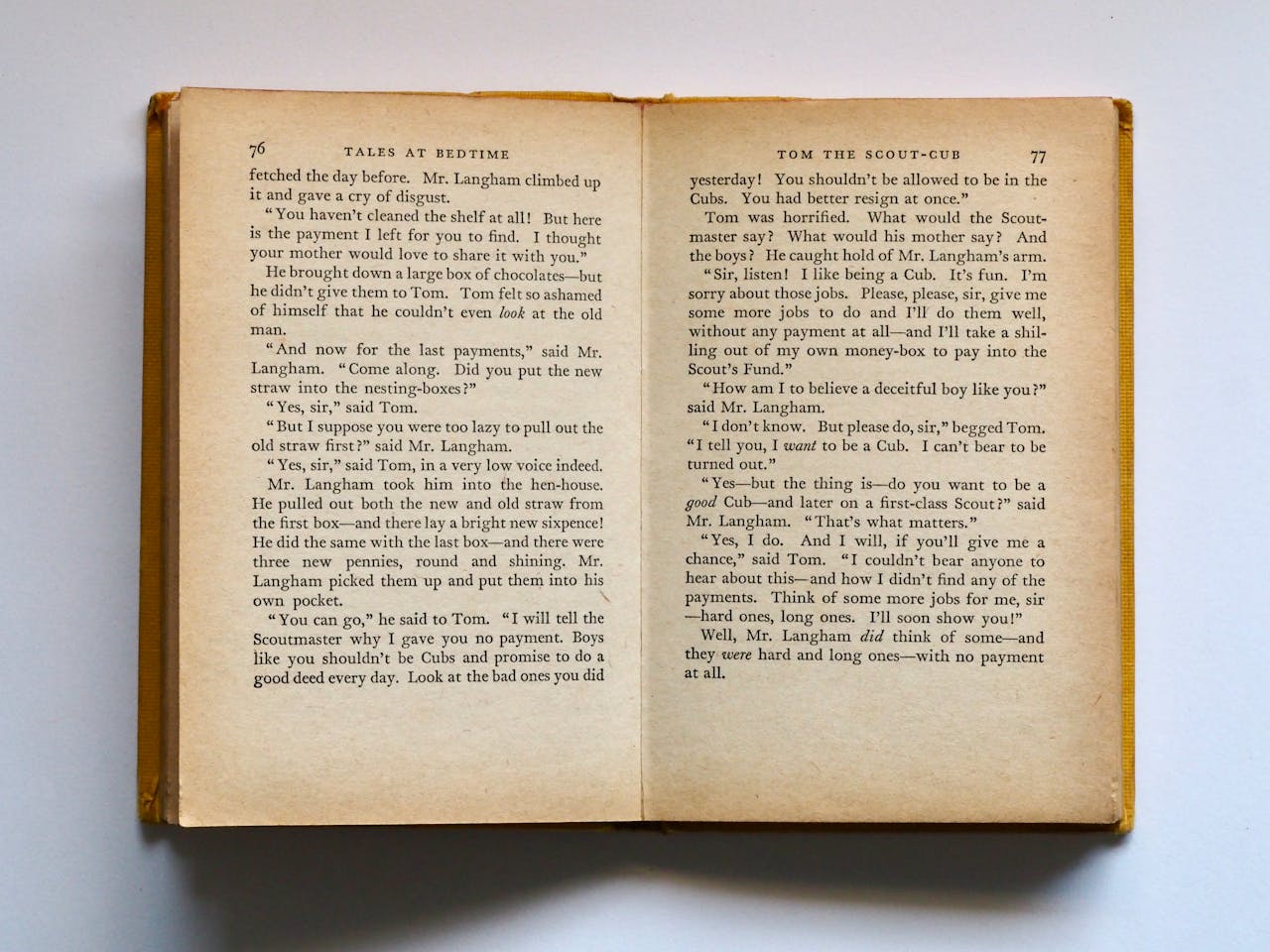 Services Vintage book opened to pages 76-77, displaying classic literature text in soft lighting.